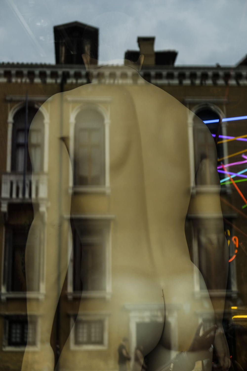 Reflected Venetian architecture and nude male mannequin