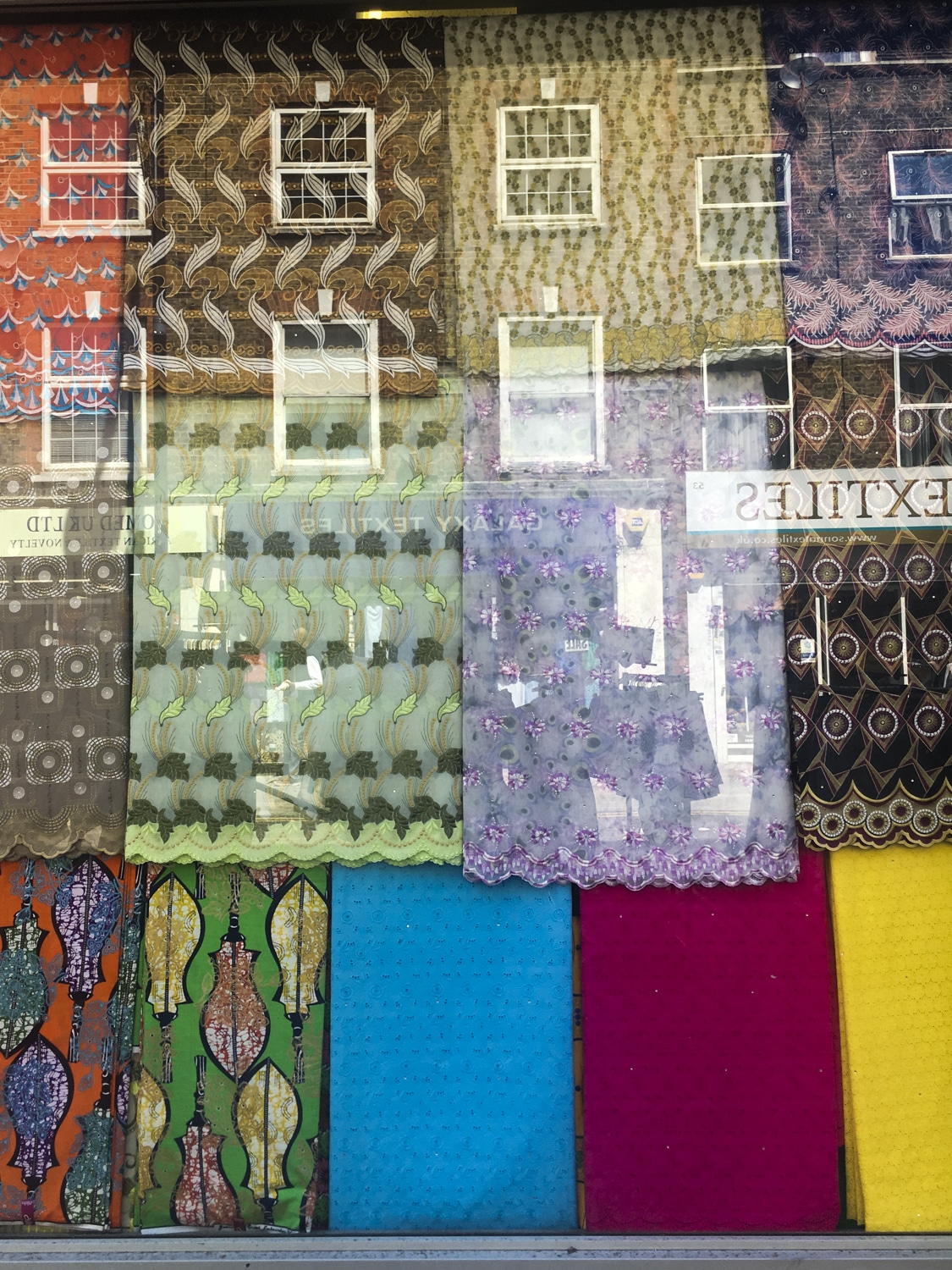 Colourful abstract with patterned fabrics and reflected buildings